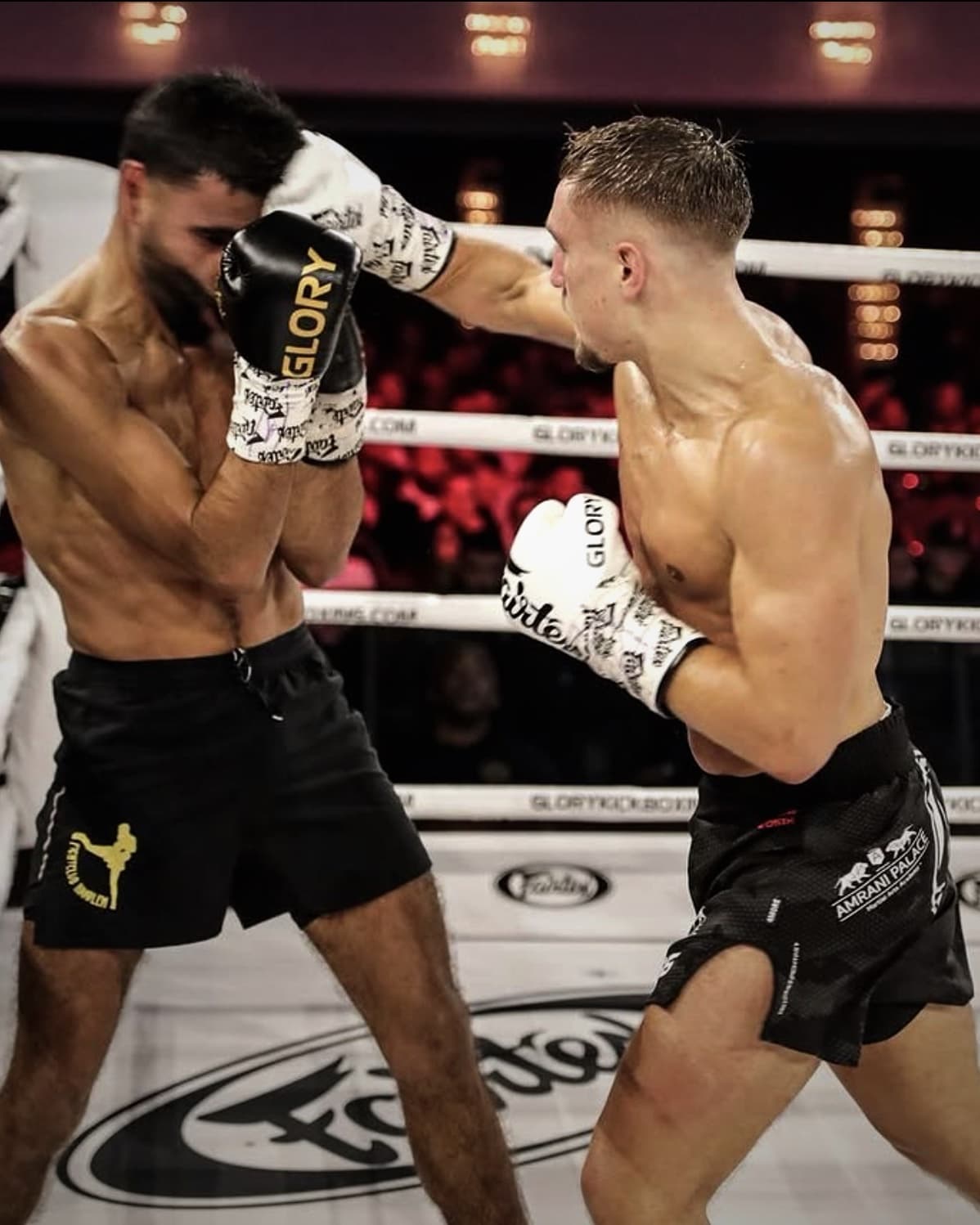 Kickboxkampf im Ring vor Publikum: Ein Kämpfer des Amrani Palace Oberhausen schlägt eine Gerade gegen die hohe Deckung seines Gegners